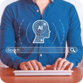 Person typing on a white keyboard with a digital AI head icon and search bar overlay, symbolizing AI marketing tools and intelligent search technology.